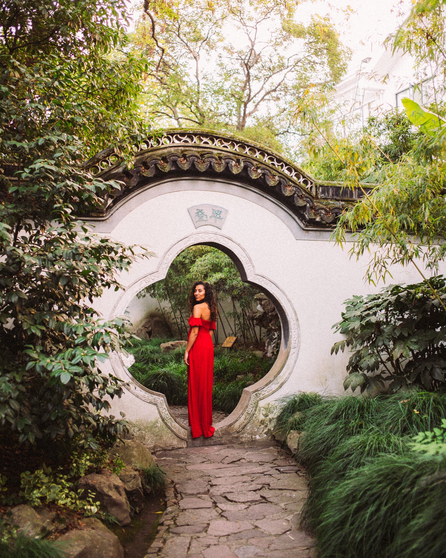 girl in red at chinese park, moon gate